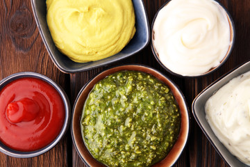 Set of sauces - ketchup, mayonnaise, mustard bbq sauce, pesto, mustard on wooden table