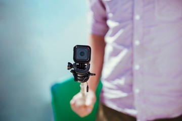 Man holding adventure camera close up on selfie stick
