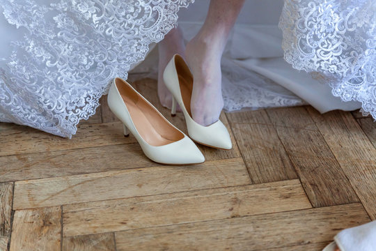 the bride wears white shoes on foot in the wedding day. close-up shoot - Powered by Adobe