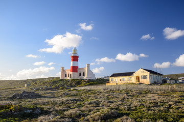 Fototapeta na wymiar Beautiful view of Cape Agulhas Lighthouse. The lighthouse is located at the southernmost point of Africa and at the same time lies at 20 degrees east latitude exactly. Popular tourist destination.