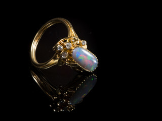 A golden ring with a colorful opal gemstone