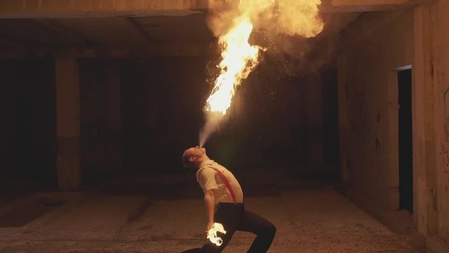 Fire show artist breathe fire in the dark, slow motion