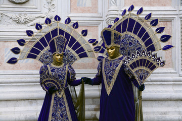 Venice Carnival masks in purple and gold Venetian costumes, Venice