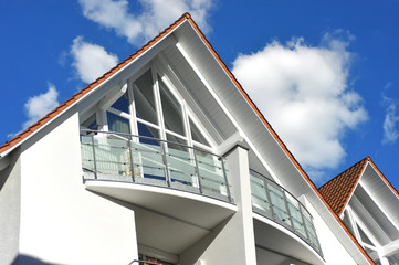 Balkon an moderner Hausfront mit Edelstahl-Glas-Geländer und Sichtschutz