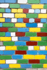 Brick wall with painted white, blue, green, red, yellow bricks