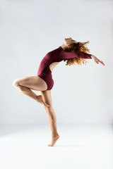 Beautiful young professional dancer dancing over white background.