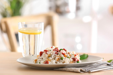 Plate with rice, sausage and vegetables on table