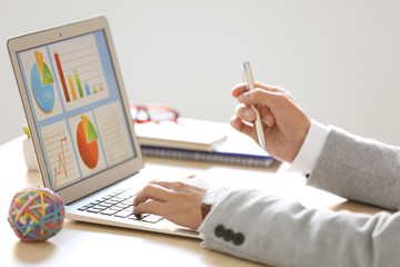Marketing manager using laptop at table in office