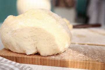 Raw puff pastry on wooden board, close up