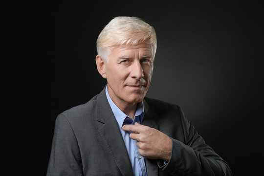 Portrait of handsome mature man on dark background