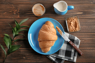 Composition with yummy fresh croissant on wooden table