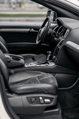 Luxury car interior. Steering wheel, shift lever and dashboard.