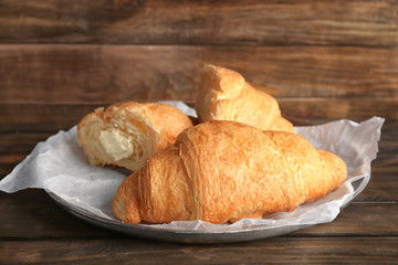 Yummy fresh croissants on wooden table