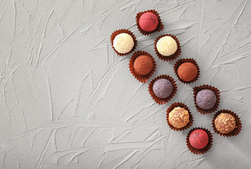 Assorted chocolate truffles on textured background