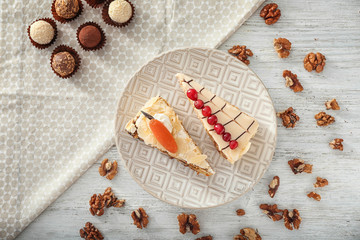 Plate with pieces of tasty cakes on table