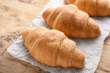 Fresh yummy croissants on wooden table