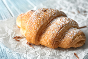 Fresh yummy croissant on parchment paper