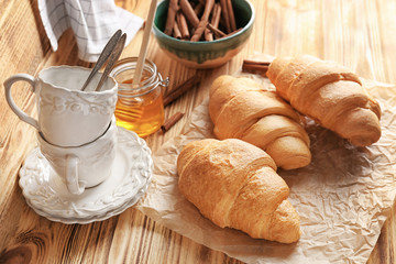 Composition with fresh yummy croissants on wooden table