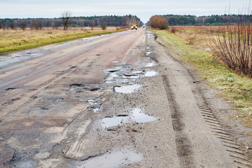 Dangerous asphalt road with holes destroyed