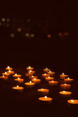 Lots of burning candles in darkness