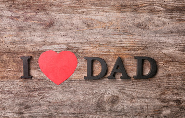 Composition with phrase I LOVE DAD for Father's Day on wooden background