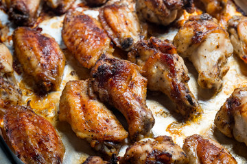 Chicken wings baked in a pan on white background isolated. Top flat, from above.