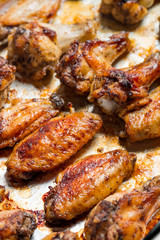 Chicken wings baked in a pan on white background isolated. Top flat, from above.
