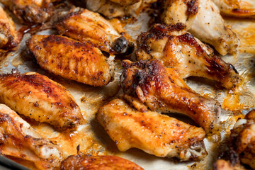 Chicken wings baked in a pan on white background isolated. Top flat, from above.