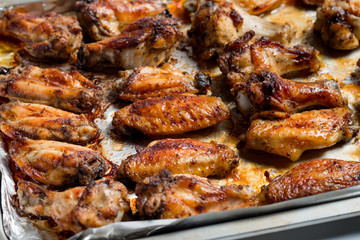 Chicken wings baked in a pan on white background isolated. Top flat, from above.