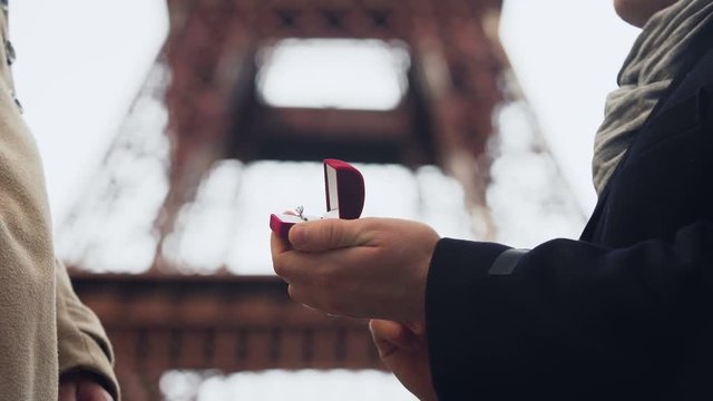 Lover making marriage proposal to his beloved girl on background of Eiffel Tower