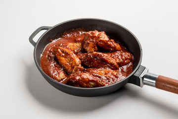 Chicken Wings BBQ in pan with red sauce. Fast food menu background isolated.