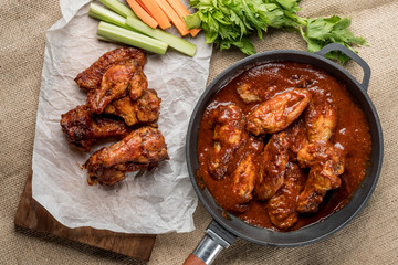 Buffalo chicken wings cooking. Food background. Flat top view, from above.