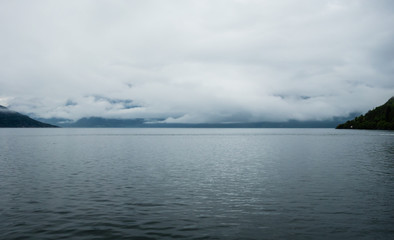 Low clouds over water in Hardangerfjord, Norway.