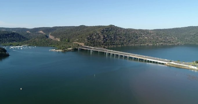 Hawkesbury river and Motorway M1 bridges on a sunny day in aerial flying forward view from East side.
