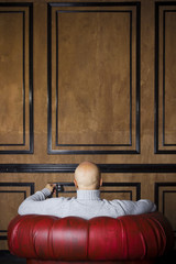 Bald man in the red armchair