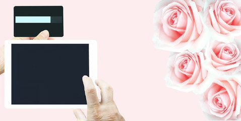 Obraz premium Valentine season sale shopping by tablet with credit card online internet connection for lover on beautiful group of pink roses background.