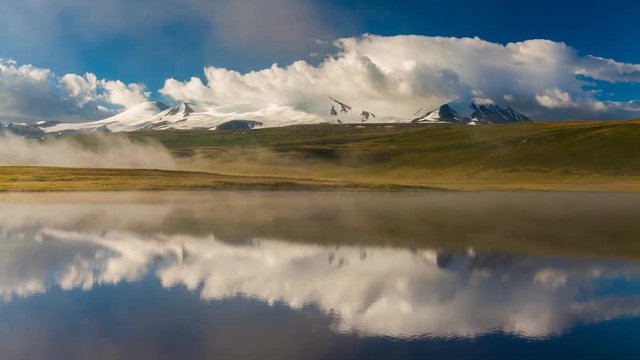 Foggy summer sunrise over mountain lake. Russia, Altai, Plateau Ukok