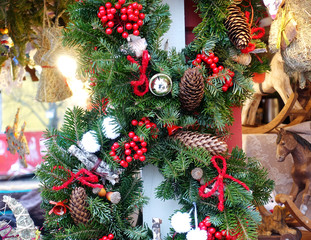 Traditional Christmas decorations from fir branches, cones and red berries with toys and gifts  