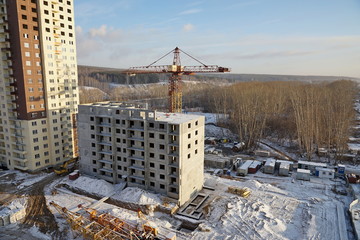 Construction site with crane and under construction high-rise apartment house. Novosibirsk Region, Russia.