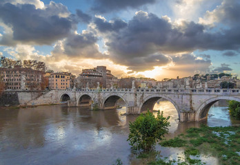 Fototapeta premium Rome (Italy) - The Tiber river and the monumental Lungotevere with 'Ponte Sant'Angelo' bridge with statues of angels