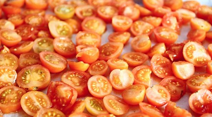sliced tomato cut in half on a baking tray stock photo	