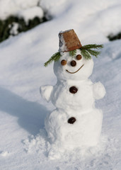Little cute smiling snowman in the garden. Having fun in wintertime.