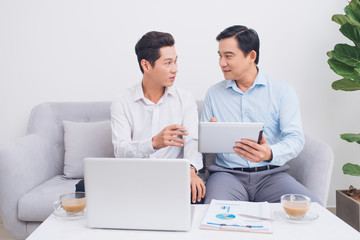 Fototapeta premium Great business discussion. Two coworkers working together around a laptop while sitting at office