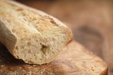 sliced fresh baguette on cutting board closeup