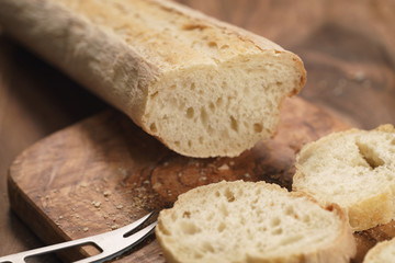 sliced fresh baguette on cutting board closeup