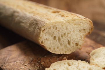 sliced fresh baguette on cutting board closeup