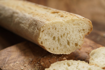 sliced fresh baguette on cutting board closeup