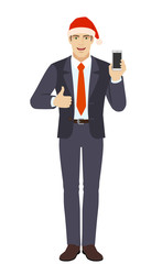 Businessman in Santa hat with mobile phone showing thumb up
