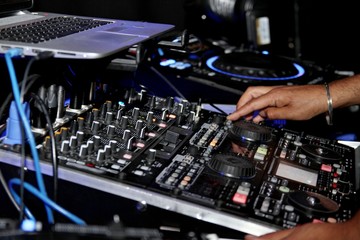 Fototapeta na wymiar DJ mixing hand on musical mixer decks stock photo