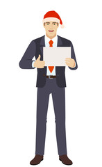 Businessman in Santa hat showing thumb up and showing the blank paper